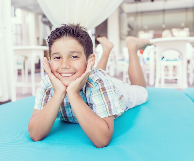 Schattige jongen genieten op turquoise bed