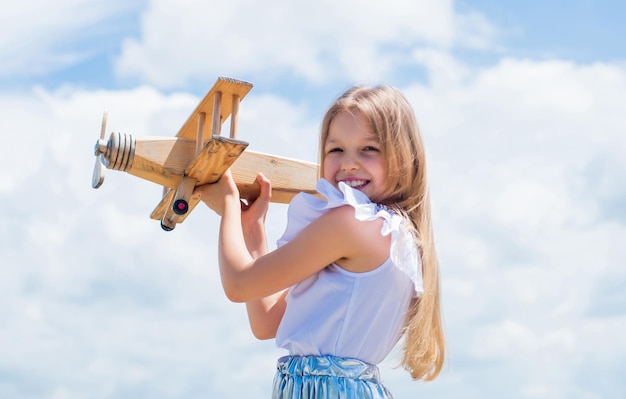 Schattige jongen houdt houten speelgoedvliegtuig op reis