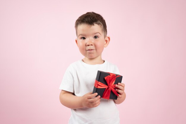 Schattige jongen in witte t-shirt met zwarte doos cadeau vooraan froze achtergrond Valentijnsdag mother39s day Hoge kwaliteit foto