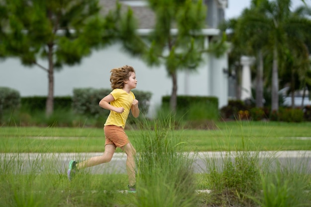 Foto schattige jongen jongen loopt door de amerikaanse wijk straat zomer kindertijd vrije tijd en mensen concept