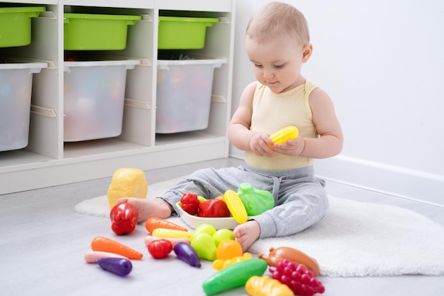 Schattige jongen meisje spelen in kleurrijke plastic speelgoed groente thuis Ontwikkeling van de vroege kinderjaren