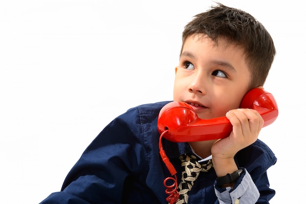 schattige jongen praten over oude telefoon tijdens het denken