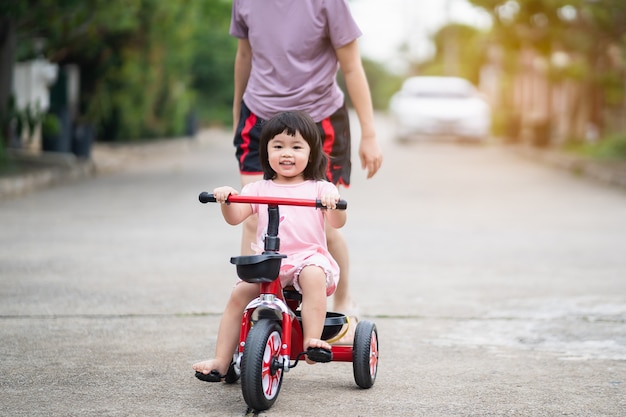 Schattige kinderen fietsen met haar moeder. kinderen genieten van een fietstocht.