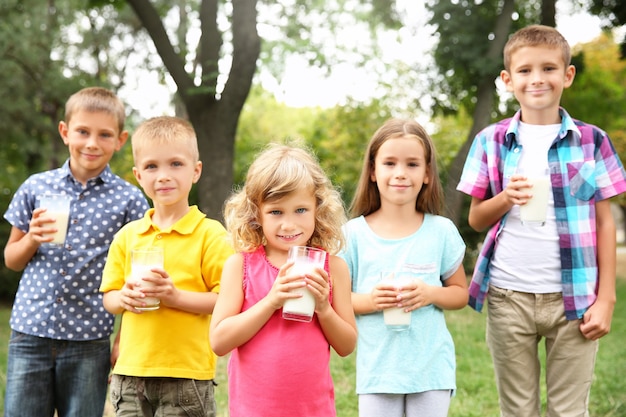 Schattige kinderen met glazen melk in het park