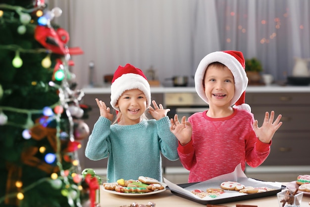 Schattige kinderen met kerstkoekjes in de keuken