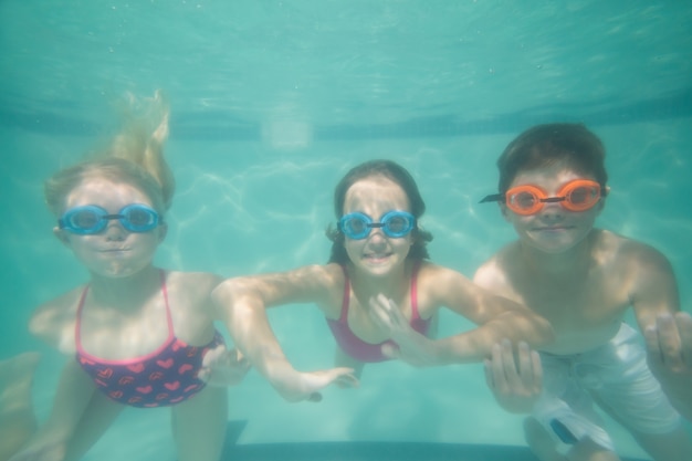 Schattige kinderen poseren onder water in het zwembad