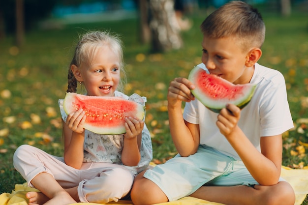 Schattige kinderen sappige watermeloen eten in de herfst park