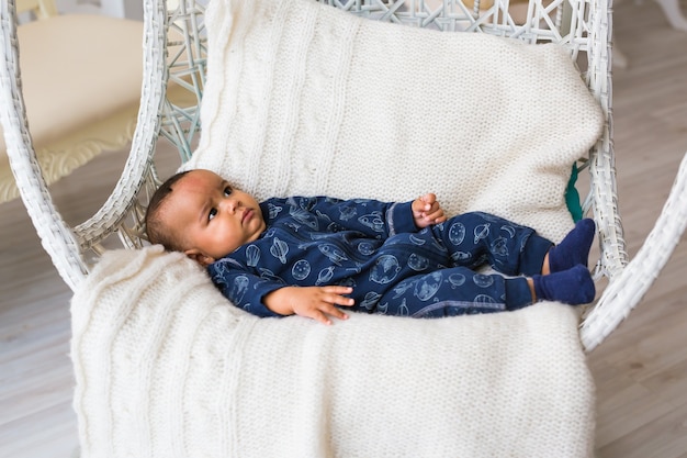 Schattige kleine Afro-Amerikaanse babyjongen op zoek. Zwarte mensen.