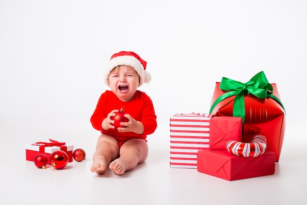 Schattige kleine baby in een kerstman kostuum met geschenken