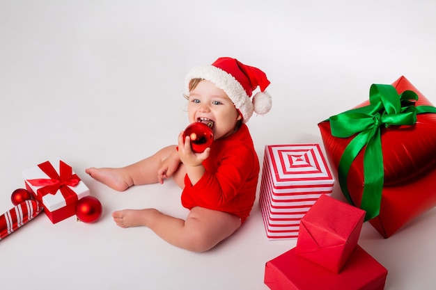 Schattige kleine baby in een kerstman kostuum met geschenken