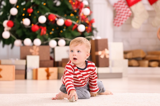 Schattige kleine baby in kamer versierd voor Kerstmis