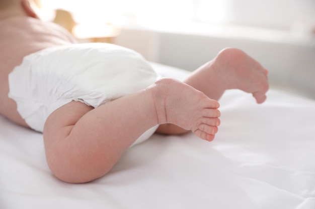 Schattige kleine baby in luier op bed close-up