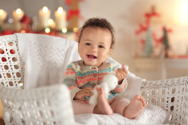 Schattige kleine baby in rieten stoel op wazig oppervlak