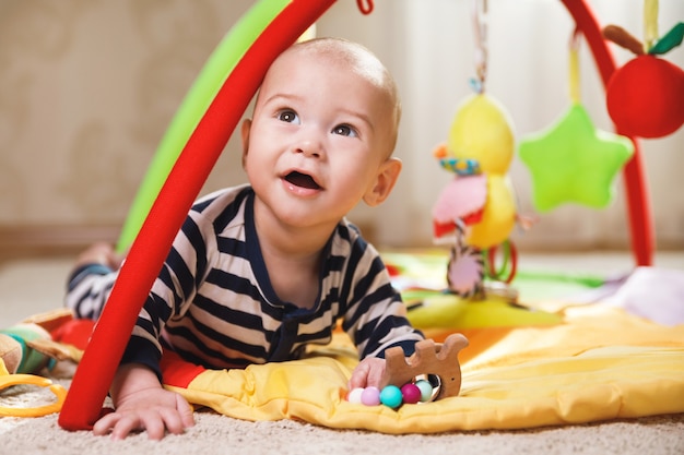 Schattige kleine baby speelt op de activiteitenmat