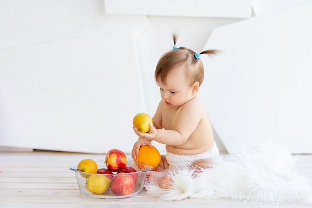 Schattige kleine babymeisje eten van fruit