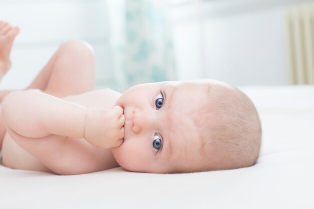 Schattige kleine babymeisje liggend met hand in de mond