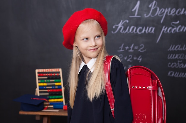 Schattige kleine blonde meisje in uniform in de klas