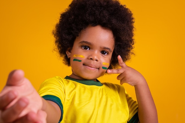 Schattige kleine Braziliaanse fan van afromeisjes die een selfie maakt met gele tshirt