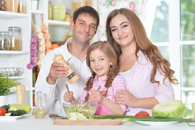 Schattige kleine dochter die salade bereidt