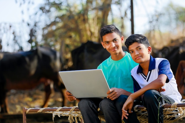 Schattige kleine Indische / Aziatische jongen die of spel met laptop computer bestudeert speelt