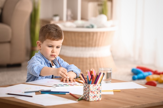 Schattige kleine jongen aan het schilderen thuis