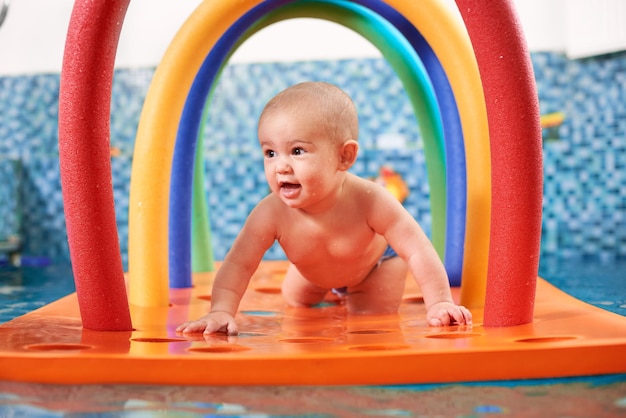 Schattige kleine jongen die in het zwembad speelt