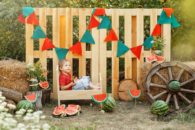 Foto schattige kleine jongen die watermeloen eet in de zomer buiten picknicktijd