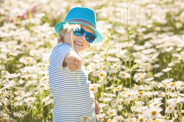 Schattige kleine jongen een kamille bloem geven