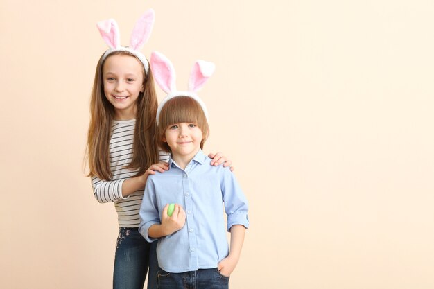 Schattige kleine jongen en meisje in konijnenoren en met een paasmandje