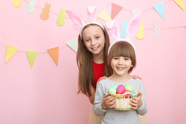 Schattige kleine jongen en meisje in konijnenoren en met een paasmandje