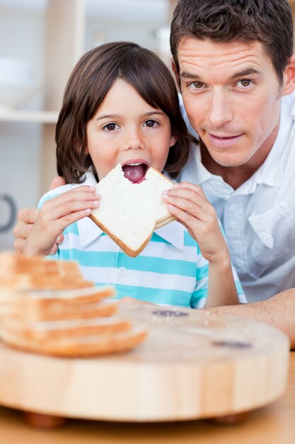 Schattige kleine jongen en zijn vader brood eten