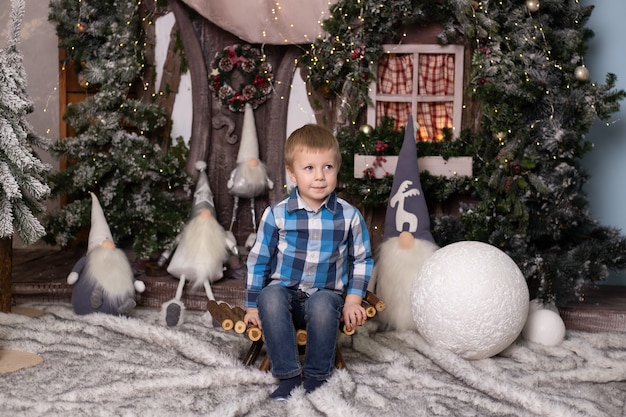 Schattige kleine jongen in de buurt van de kerstboom