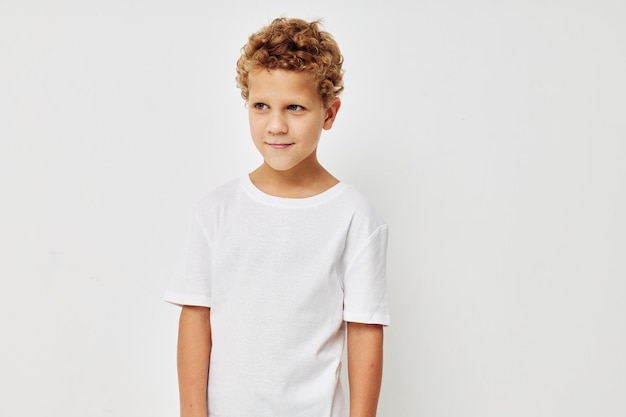 Schattige kleine jongen in een witte t-shirt poseren leuke geïsoleerde achtergrond