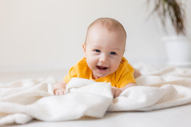 Schattige kleine jongen in geel lichaam op deken, kaart, banner, gezondheid, ruimte voor tekst