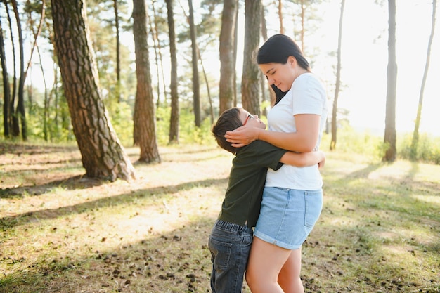 Schattige kleine jongen in zijn moeder wandelen in de natuur