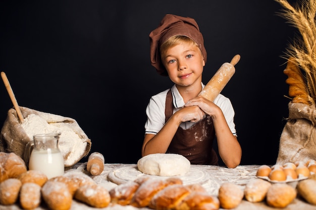 Schattige kleine jongen met chef-kok hoed koken