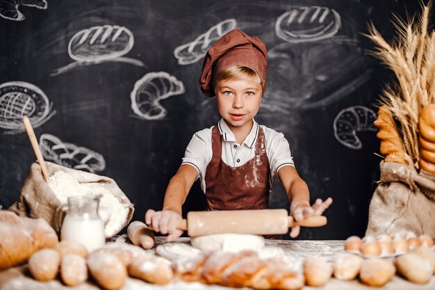 Schattige kleine jongen met chef-kok hoed koken