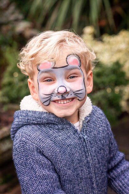 Schattige kleine jongen met zijn gezicht geschilderd