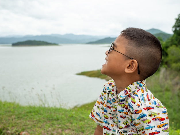 Schattige kleine jongen naast een reservoir in Thailand