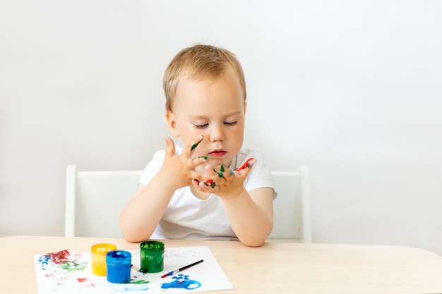 Schattige kleine jongen permanent aan de tafel