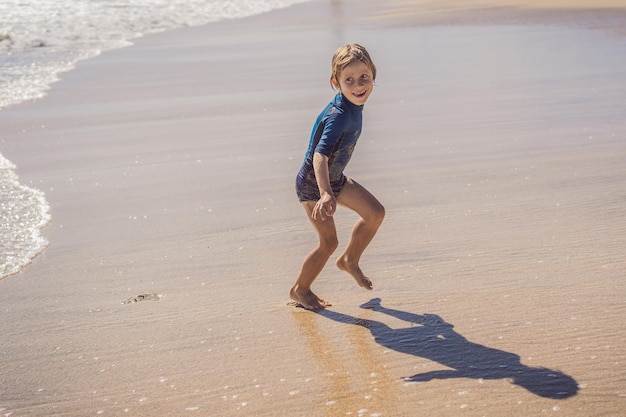 Schattige kleine jongen plezier op tropisch strand tijdens de zomervakantie