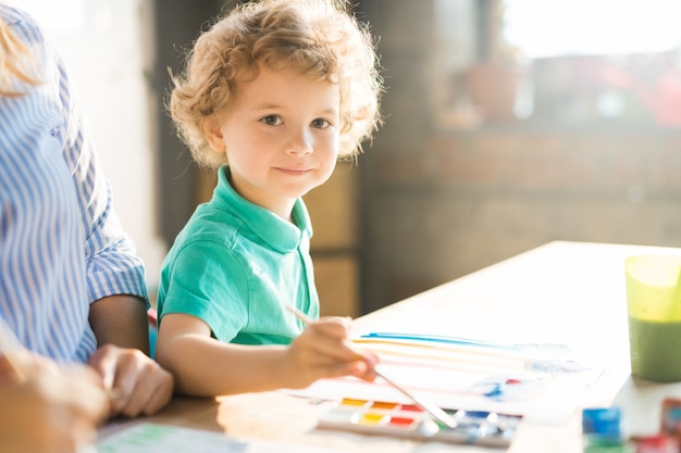 Schattige kleine jongen schilderij in zonlicht