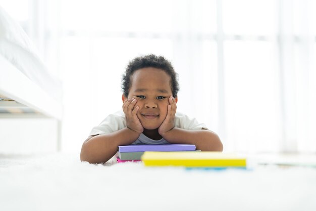 Schattige kleine jongen slapen op witte vloer in slaapkamer Er waren veel stapels boeken