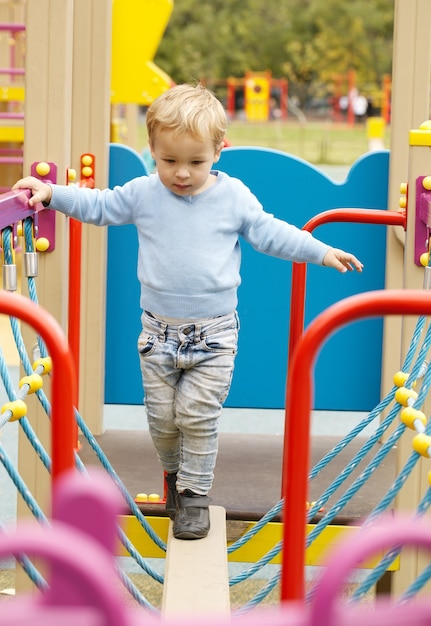 Schattige kleine jongen speelt in een speeltuin