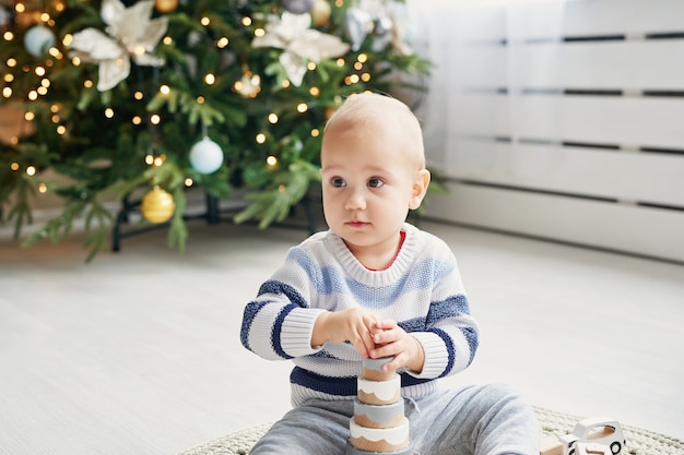 Schattige kleine jongen speelt met speelgoed houten trein, speelgoedauto, piramide en kubussen, leren ontwikkelingsconcept. ontwikkeling van fijne motoriek van kinderen, verbeelding en logisch denken