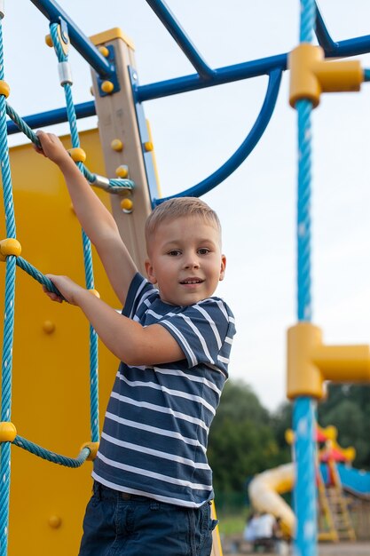 Schattige kleine jongen spelen in de speeltuin