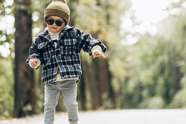 Schattige kleine jongen staande op de weg in het park