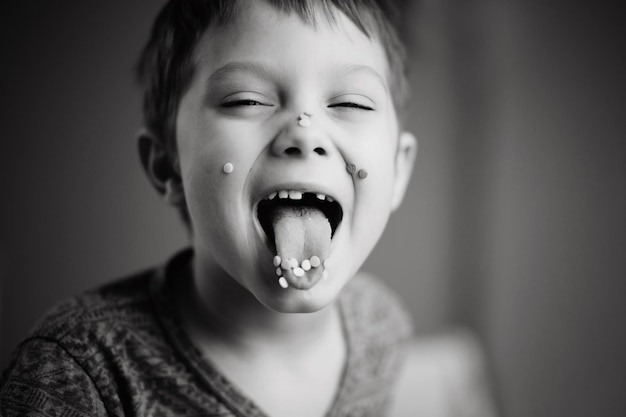 Schattige kleine jongen steekt zijn tong uit bedekt met suiker topping Afbeelding met selectieve focus