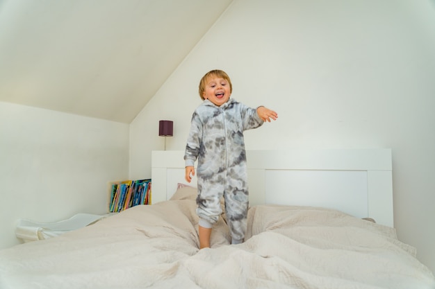 Schattige kleine jongen van drie jaar oud spelen in de slaapkamer thuis