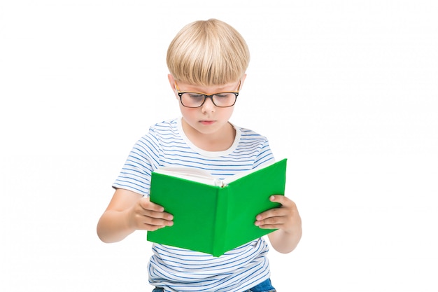 Schattige kleine kind met boeken en notebooks schattige jongen lezen. schooljongen studio-opname. jongen die oogglazen draagt.